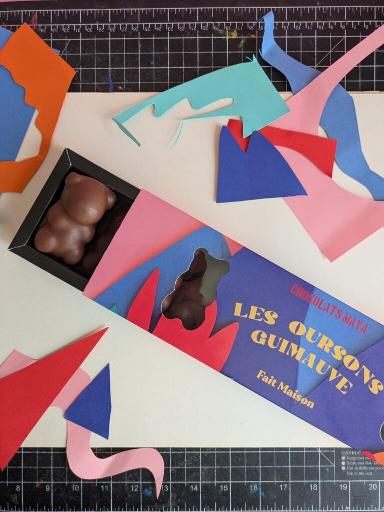 Détail d’une boîte ouverte d’oursons guimauve sur fond de découpage coloré